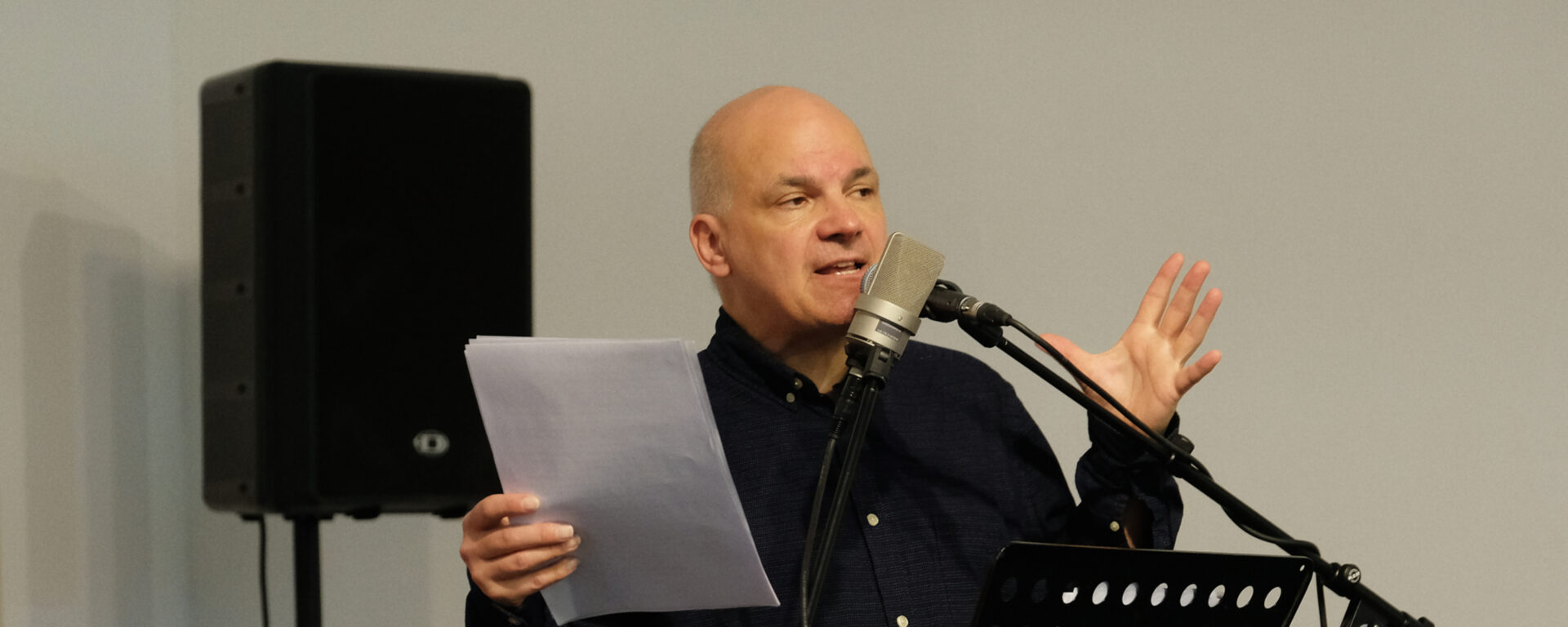 Autor Frank Witzel steht am Mikrofon während einer Lesung